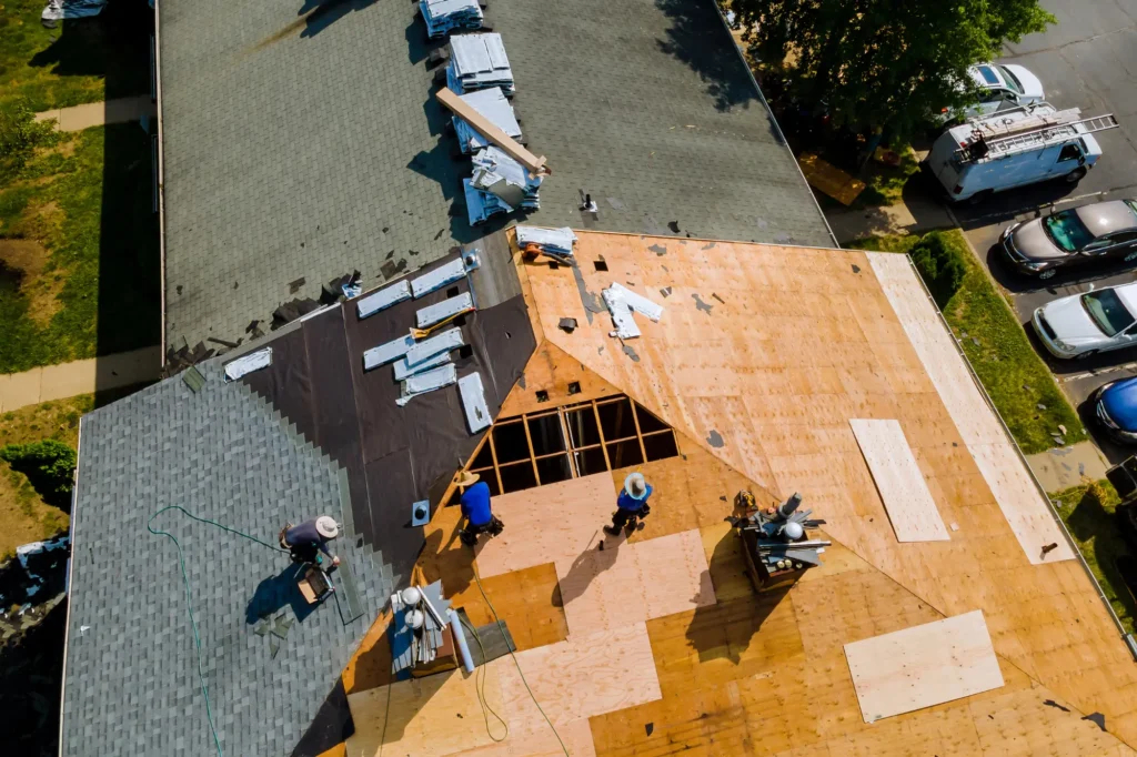 Roofing crew installing new shingles for a roof of a house